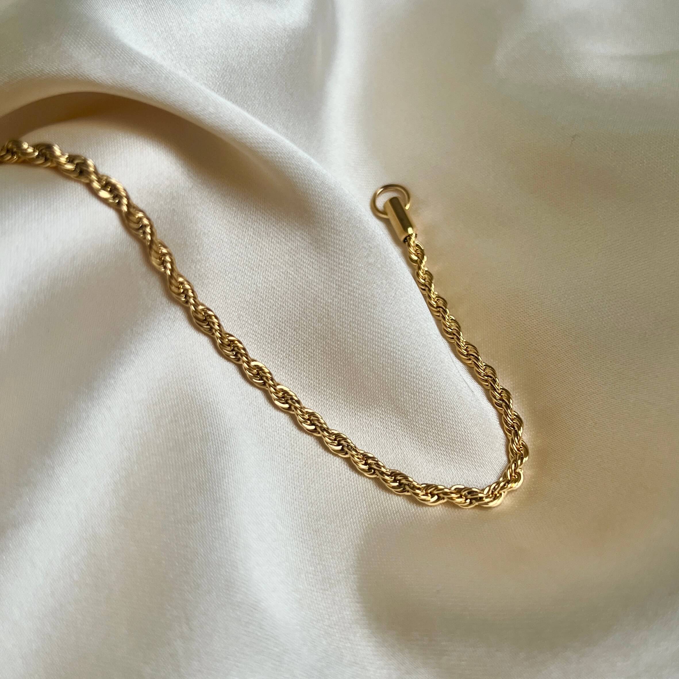 Aloe Allie Bracelet – tvinnat guldarmband i rostfritt stål från Alora Avenue, elegant och vattentåligt med lyxig glans.