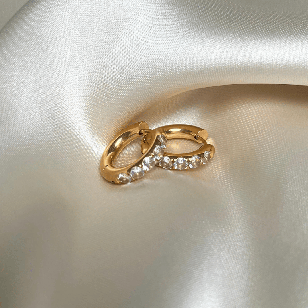 Ana Aura Hoops i 18K guld PVD-plätering med gnistrande cubic zirconia-stenar, vattentåliga och allergivänliga för långvarig glans.