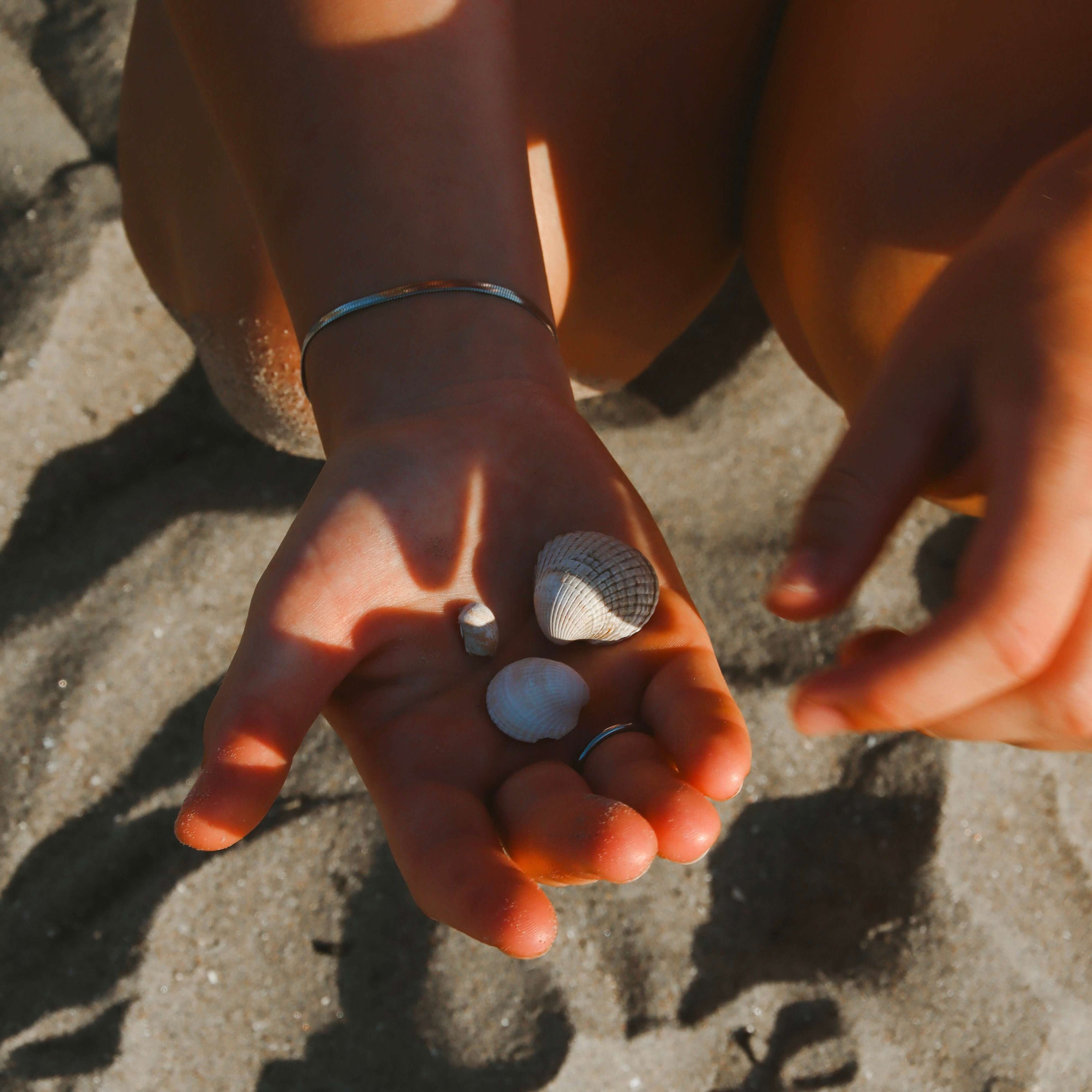 Närbild på Carrie Cobra Bracelet från Alora Avenue, ett tidlöst armband i silverfärgat rostfritt stål. Vattentåligt och allergivänligt smycke, perfekt att bära både på stranden och till vardags.