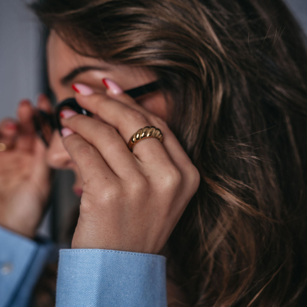 Classic Croissant Ring från Alora Avenue bärs med självsäker elegans – en vattentålig och allergivänlig guldring som lyfter varje outfit. Perfekt för vardagens power moves, där stil, styrka och guldkant möts i ett tidlöst smycke.