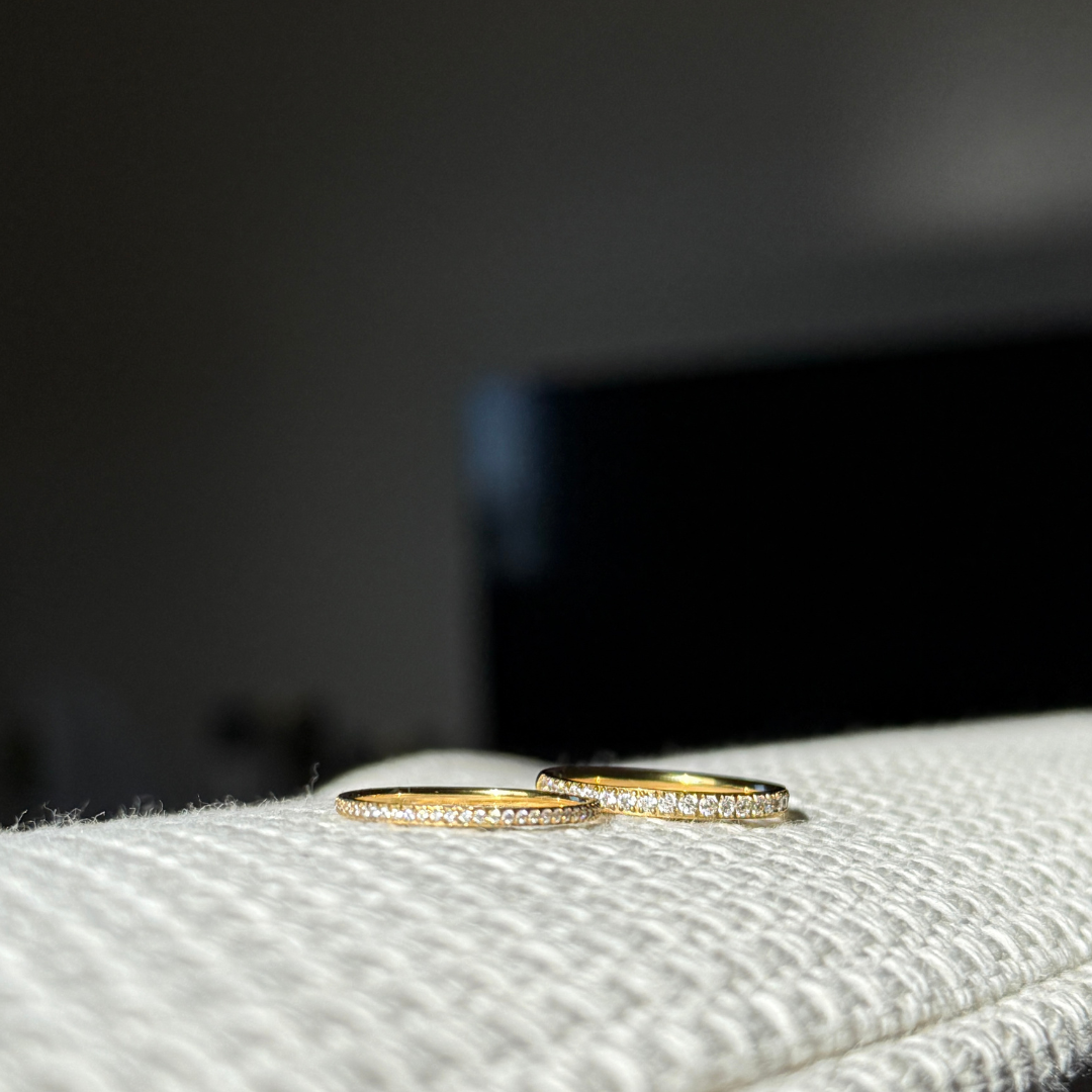 Elara Glow Ring Ina Spark Ring i guld med klara stenar som löper halvvägs runt ringen. Elegant, tunn och vattentålig ring från Alora Avenue i rostfritt stål med PVD-plätering.