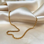 Aloe Annie Necklace – elegant guldcordellhalsband med snurrad design, 45 cm långt och 3 mm brett, tillverkat i hållbart rostfritt stål med PVD-plätering.