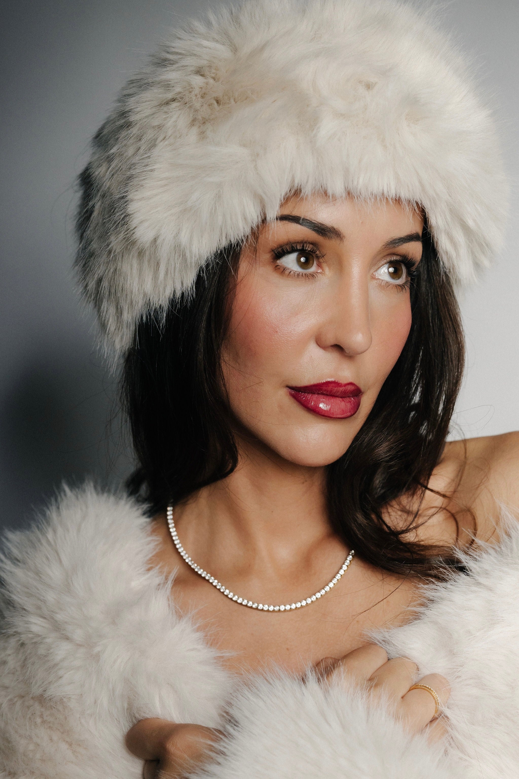 Kvinna bär Alora Avenue Amara Tennis Necklace – ett vattentåligt och allergivänligt halsband i rostfritt stål med 18K PVD-plätering, perfekt som julklapp till kvinnor som vill ha hållbara smycken som inte tappar färg. Bilden visar hur halsbandet glittrar vackert mot vinterljuset, ett elegant och tidlöst smycke som passar både till fest, nyår och vardag.