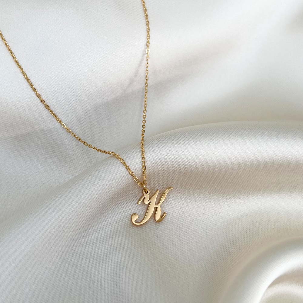 Elegant Alora Letter Necklace med bokstaven K i skrivstil, ett halsband i allergivänligt material som utstrålar stil och hållbarhet.