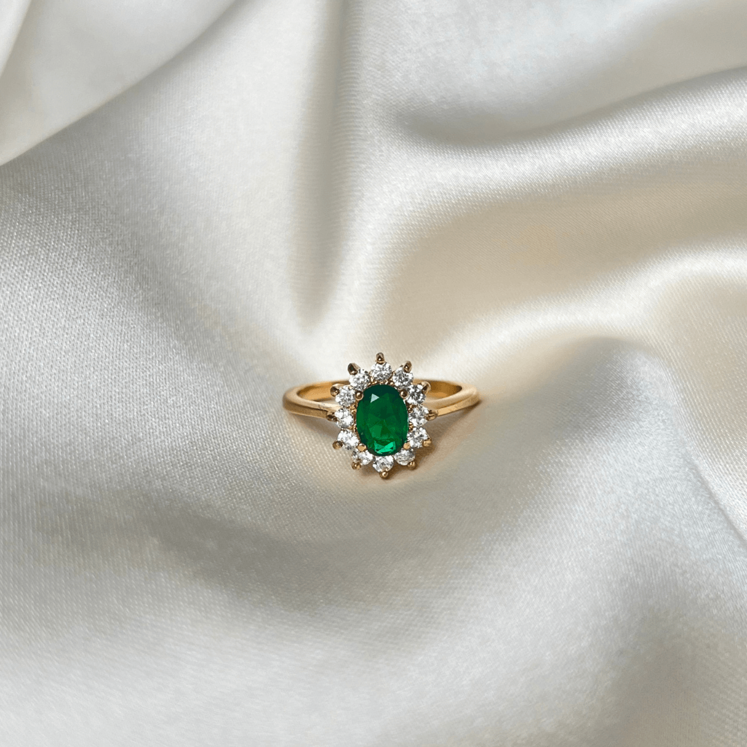 Celine Carmosé Ring är en unik carmoséring med en fängslande grön sten i centrum, omgiven av gnistrande vita stenar. 