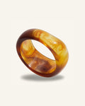 Costa Tigre Bangle — Marmorerad tortoise-akrylbangle i amber och brunt på beige bakgrund | Alora Avenue