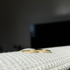 Elara Glow Ring Ina Spark Ring i guld med klara stenar som löper halvvägs runt ringen. Elegant, tunn och vattentålig ring från Alora Avenue i rostfritt stål med PVD-plätering.