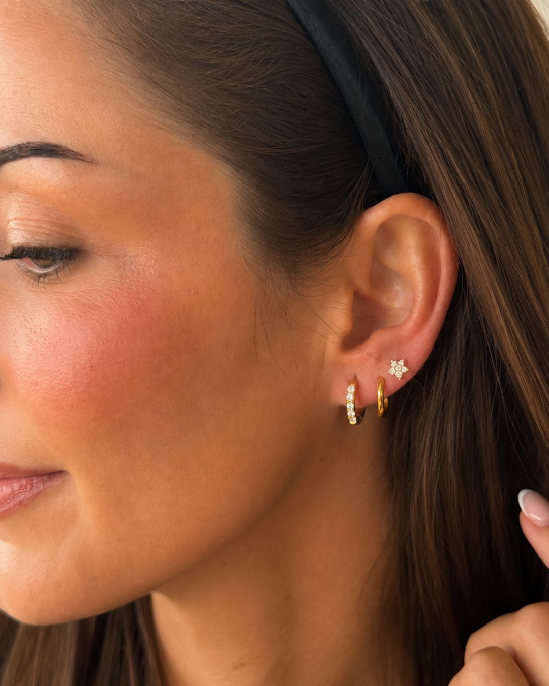 Flora Flower Stud i en ear stack på modell – guldigt blomörhänge med cubic zirconia | Alora Avenue