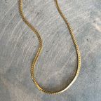 Girly Grace Necklace – guldfärgat halsband i rundad pansar-stil, 42 cm långt, med hållbar PVD-plätering och vattentålig design.