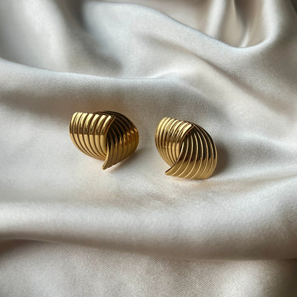 Vattentåliga Hanna Huggie Earrings i guld med omfamnande design. Tillverkade i rostfritt stål med PVD-plätering för stil och hållbarhet.