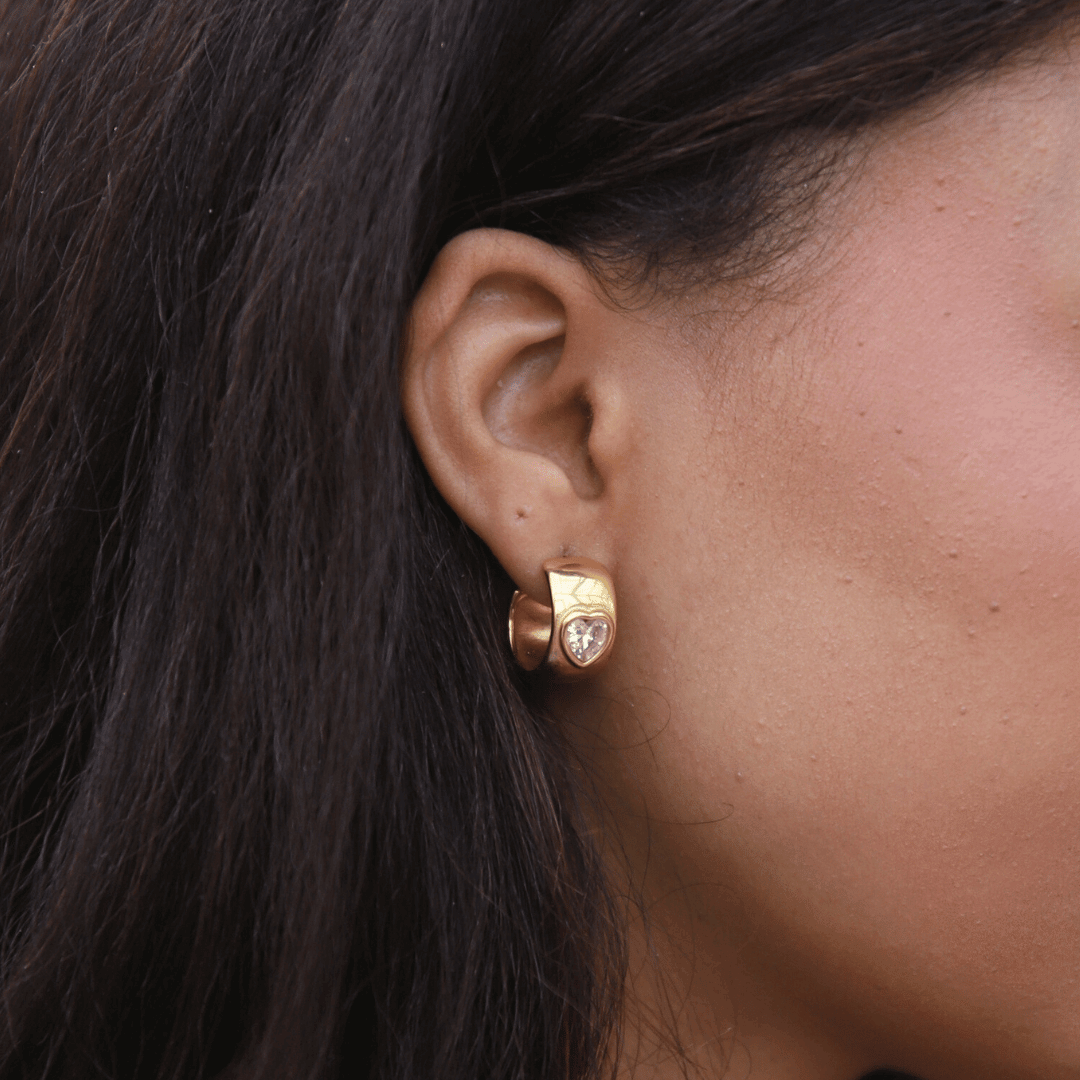 Havanna Heart Earrings – chunky halvhoops i 18K guld med gnistrande zirconia-hjärtan. Romantiska och vattentåliga.