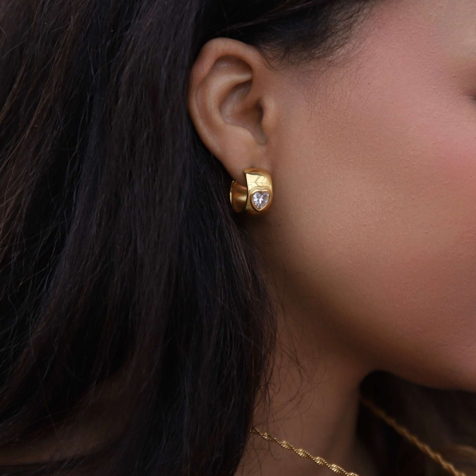 Närbild på Havanna Heart Earrings i guld från Alora Avenue – hjärtformade stenar infattade i vattentåliga och allergivänliga örhängen i tidlös design.
