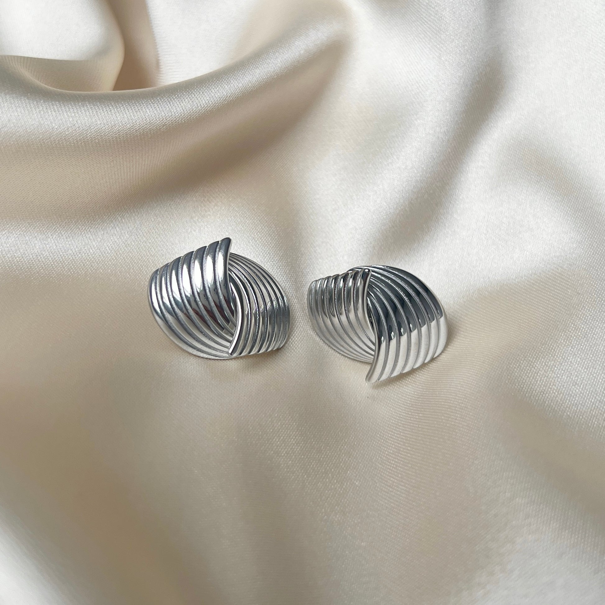 Holly Huggie Earrings i silver, som ger en sofistikerad och modern look. PVD-pläterade för hållbarhet och vattentåliga, dessa örhängen är en favorit för alla tillfällen.