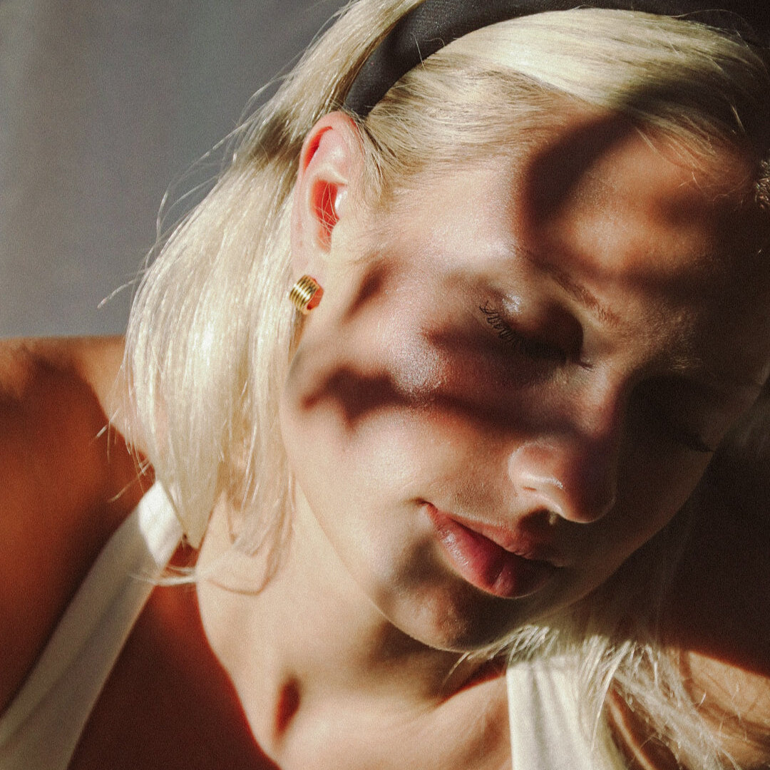 Kvinna bär Kairo Vintage Hoops i guld från Alora Avenue – vattentåliga och allergivänliga vintageinspirerade örhängen i tidlös design.