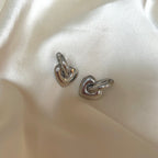 Leia Love Loops från Alora Avenue – vattentåliga och allergivänliga örhängen i blankt rostfritt stål med hjärtformade hängen i helsilver. Stilrena hoops med en mjuk, romantisk form – perfekta som vardagsfavorit eller tidlös gåva i minimalistisk design.