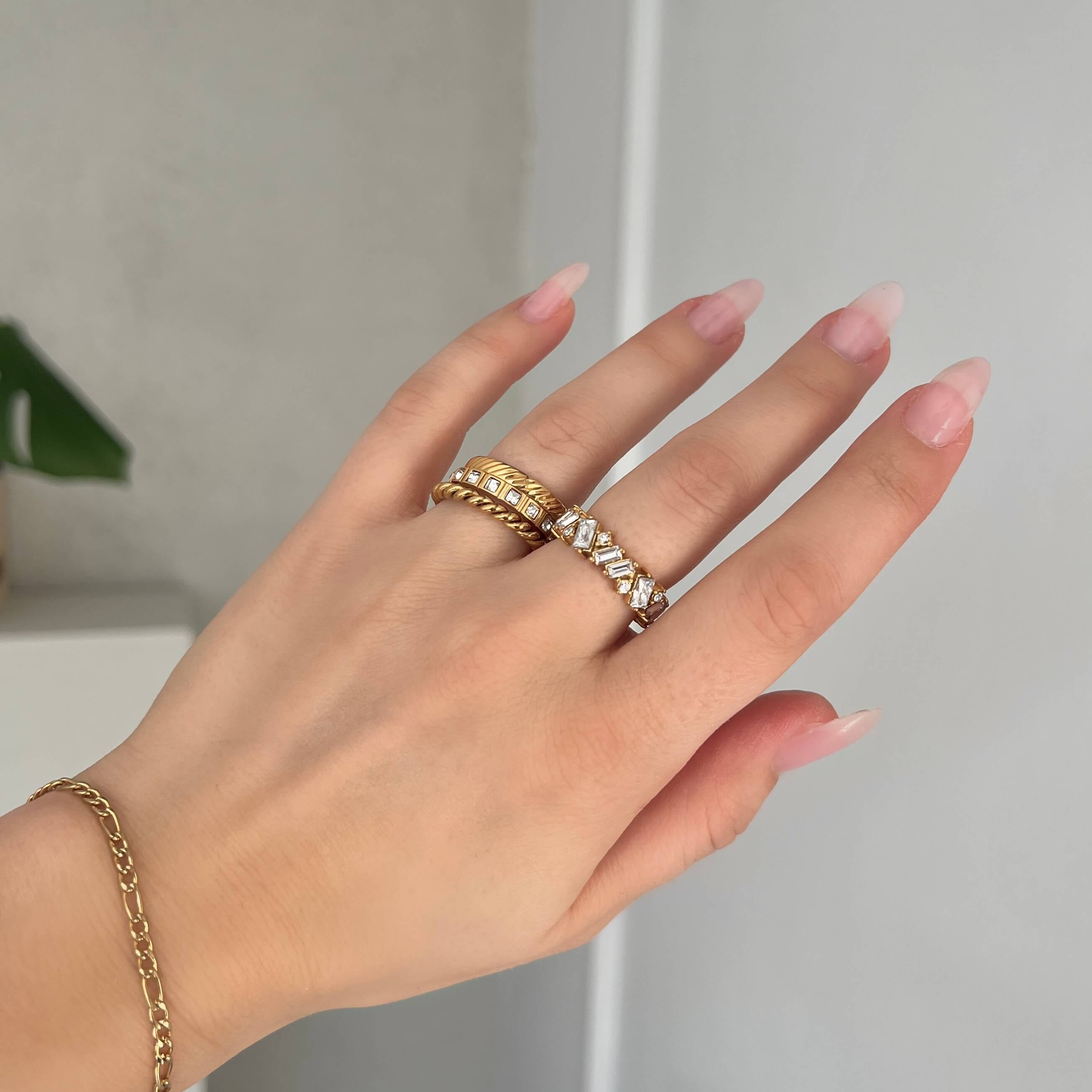 Messy Crystal Ring från Alora Avenue – en guldfärgad ring med unikt placerade, skimrande kristaller. Vattentålig och allergivänlig – perfekt för dig som vill sticka ut, utan att kompromissa med komfort eller stil. Ett smycke för den som vet att det är detaljerna som gör looken.