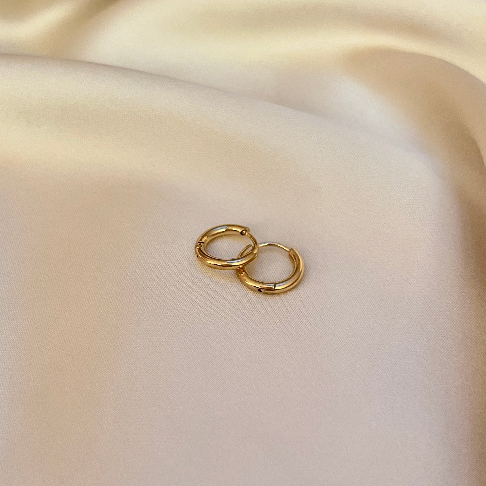 Mini Luna Hoops från Alora Avenue – små, tunna guldhoops i tidlös design. Perfekta vardagsörhängen i vattentåligt och allergivänligt material. Stilrent smycke för alla tillfällen.