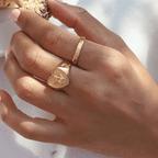 Oblique Olga Ring är en tunn guldring med diagonala ränder som skapar ett modernt och tidlöst uttryck.