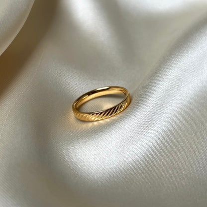 Oblique Olga Ring i 18K guld med subtila diagonala ränder. Tillverkad i rostfritt stål och PVD-plätering, vattentålig och hållbar för långvarig glans.