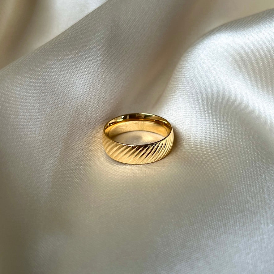 Elegant Oblique Olive Ring med diagonala ränder, 6 mm bred, i 18K guldplätering. Vattentålig och slitstark för dagligt bruk.