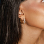 Sabrina Spark Hoops är glittrande hoops i guld, prydda med cubic zirconia-stenar som ger ett elegant och glittrande intryck. 