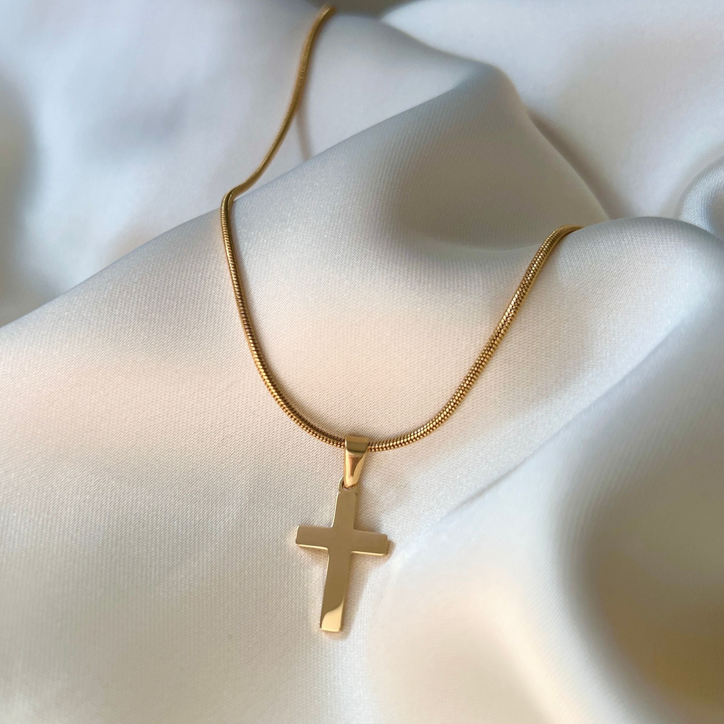 Slytherin Neat Necklace – guldrund ormkedja, 45 cm lång, tillverkad av återvinningsbart rostfritt stål och PVD-pläterad med 18K guld för hållbar glans och vattentålighet tillsammans med ett stiligt kors.