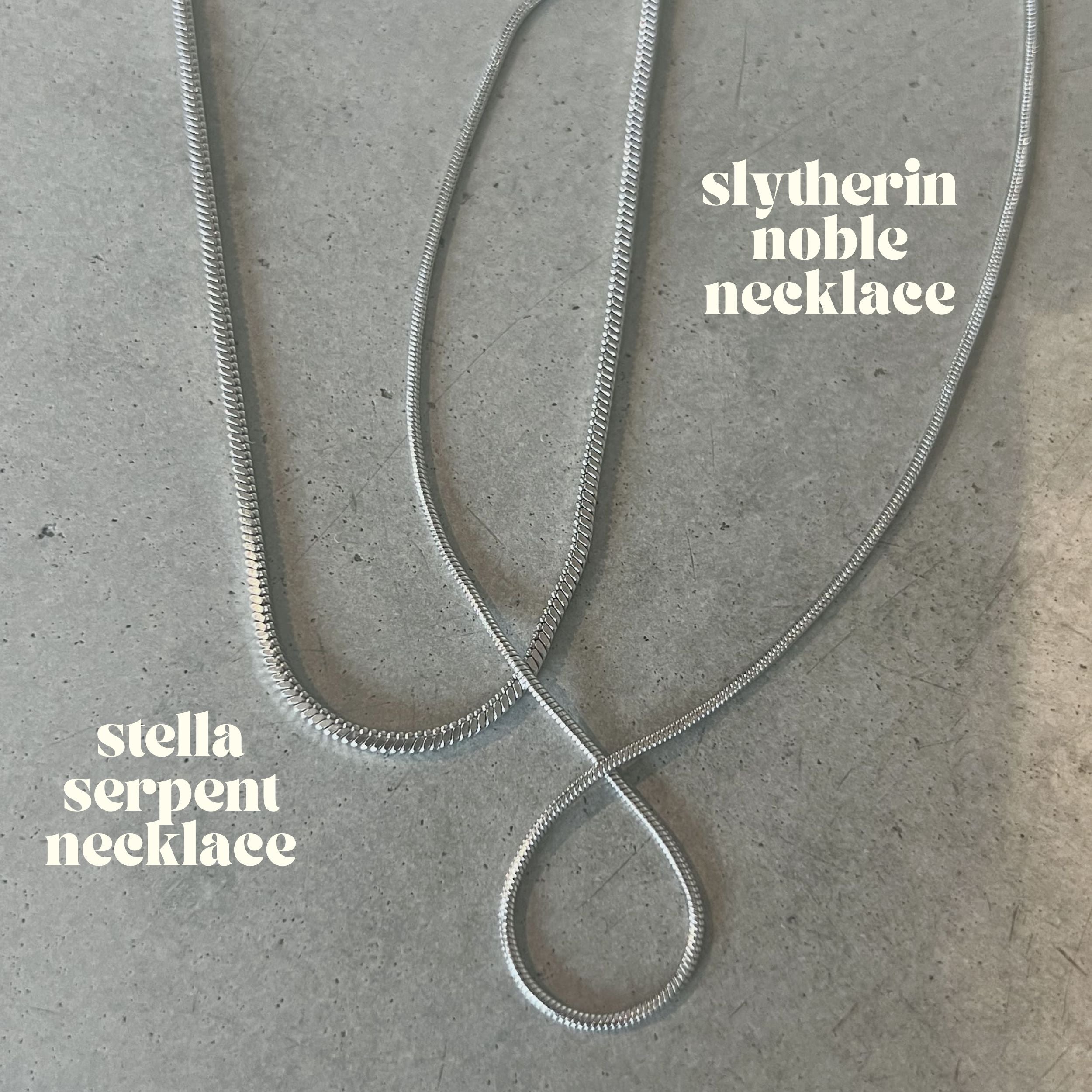 Slytherin Noble Necklace – sofistikerad silvrig rundad ormkedja på 45 cm, tillverkad i rostfritt stål och PVD-pläterad för vattentålighet och långvarig hållbarhet.