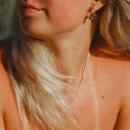 Slytherin Noble Necklace på modell, ett elegant silverfärgat halsband i rostfritt stål. Vattentåligt och allergivänligt smycke från Alora Avenue, en tidlös kedja som lyfter varje outfit.