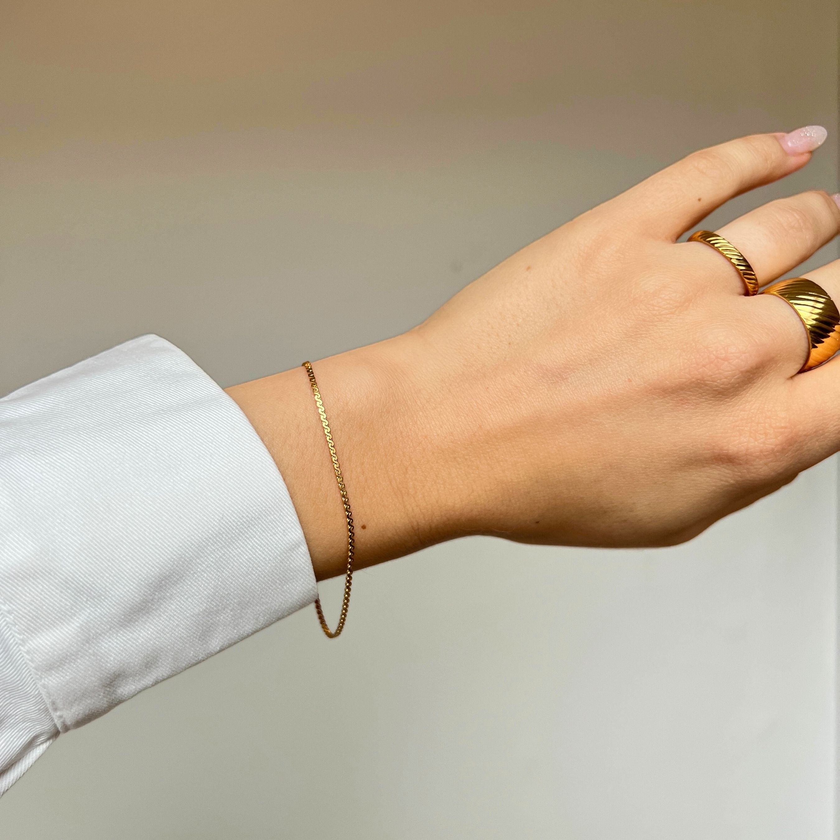 Sonya Saffron Bracelet är ett elegant S-länksarmband i 18K guldplätering, tillverkat i rostfritt stål för hållbarhet och vattentålighet.