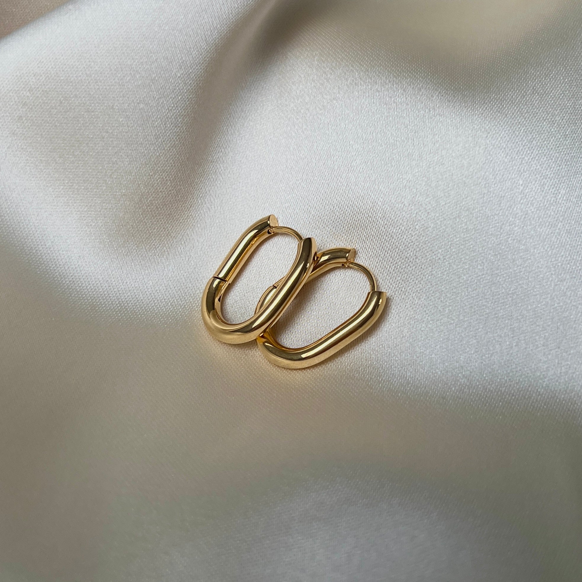 Vattentåliga Stellar Serenity Hoops i 18K guldplätering med oval design, tillverkade i allergivänligt rostfritt stål.