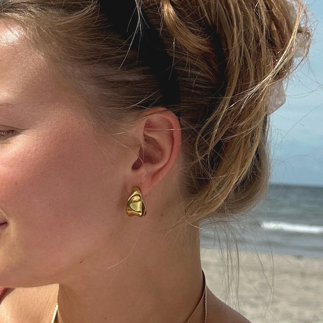 Stockholm Echo Earrings kombinerar stil och funktion med sin vattentåliga PVD-plätering i guld. Tillverkade i rostfritt stål för långvarig glans, ger dessa örhängen en elegant touch till din look.