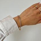 Tilda Tennis Bracelet är ett guldigt tennisarmband med cubic zirconia-stenar, tillverkat i rostfritt stål och PVD-pläterat för långvarig glans.
