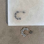 Tornado Edge earrings - Eleganta, snurrade halvhoops i silver med hållbar PVD-plätering, modern design och sofistikerad stil.