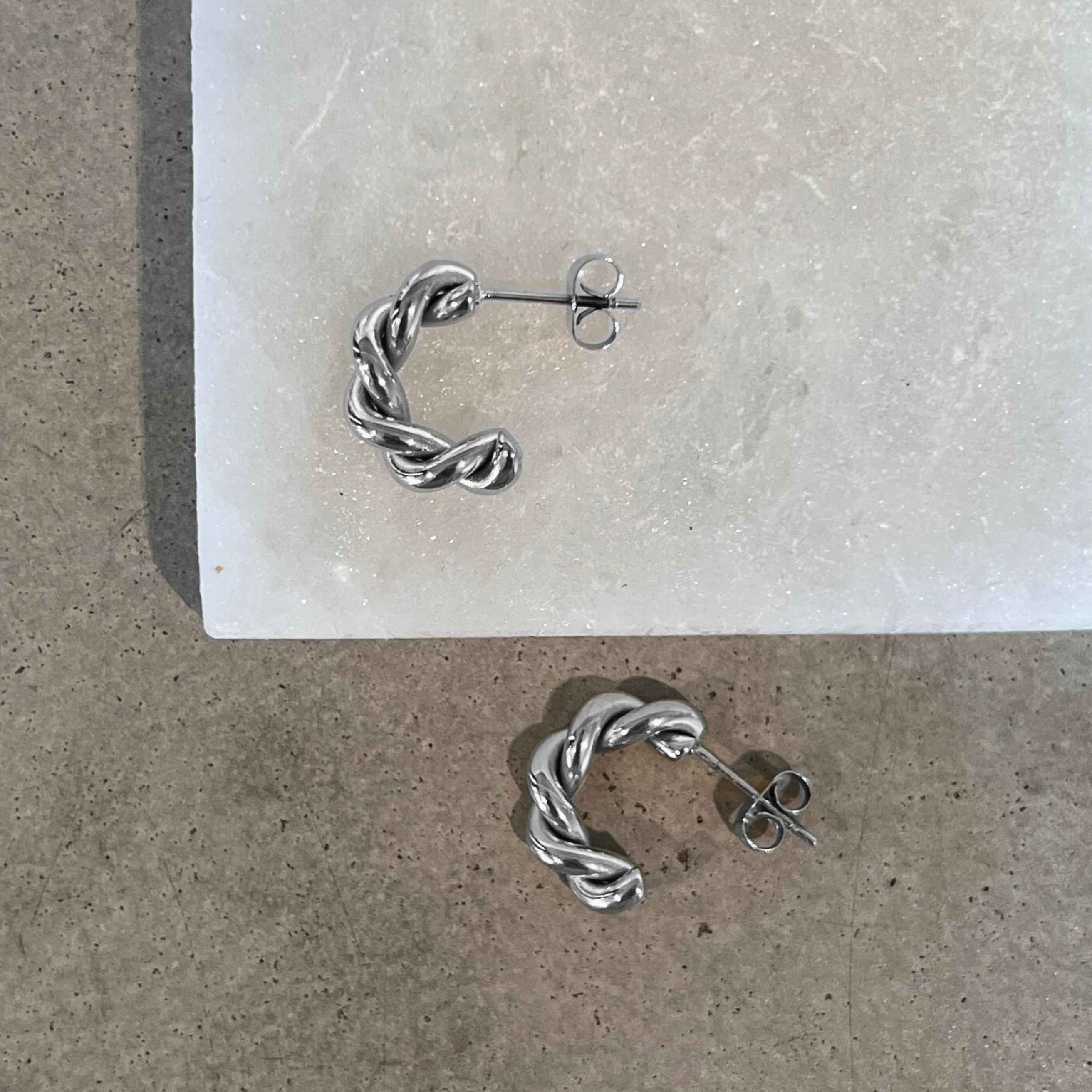 Tornado Edge earrings - Eleganta, snurrade halvhoops i silver med hållbar PVD-plätering, modern design och sofistikerad stil.