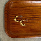 Tornado Ember Earrings – Guldiga halvhoops med skruvad virvelvindseffekt.