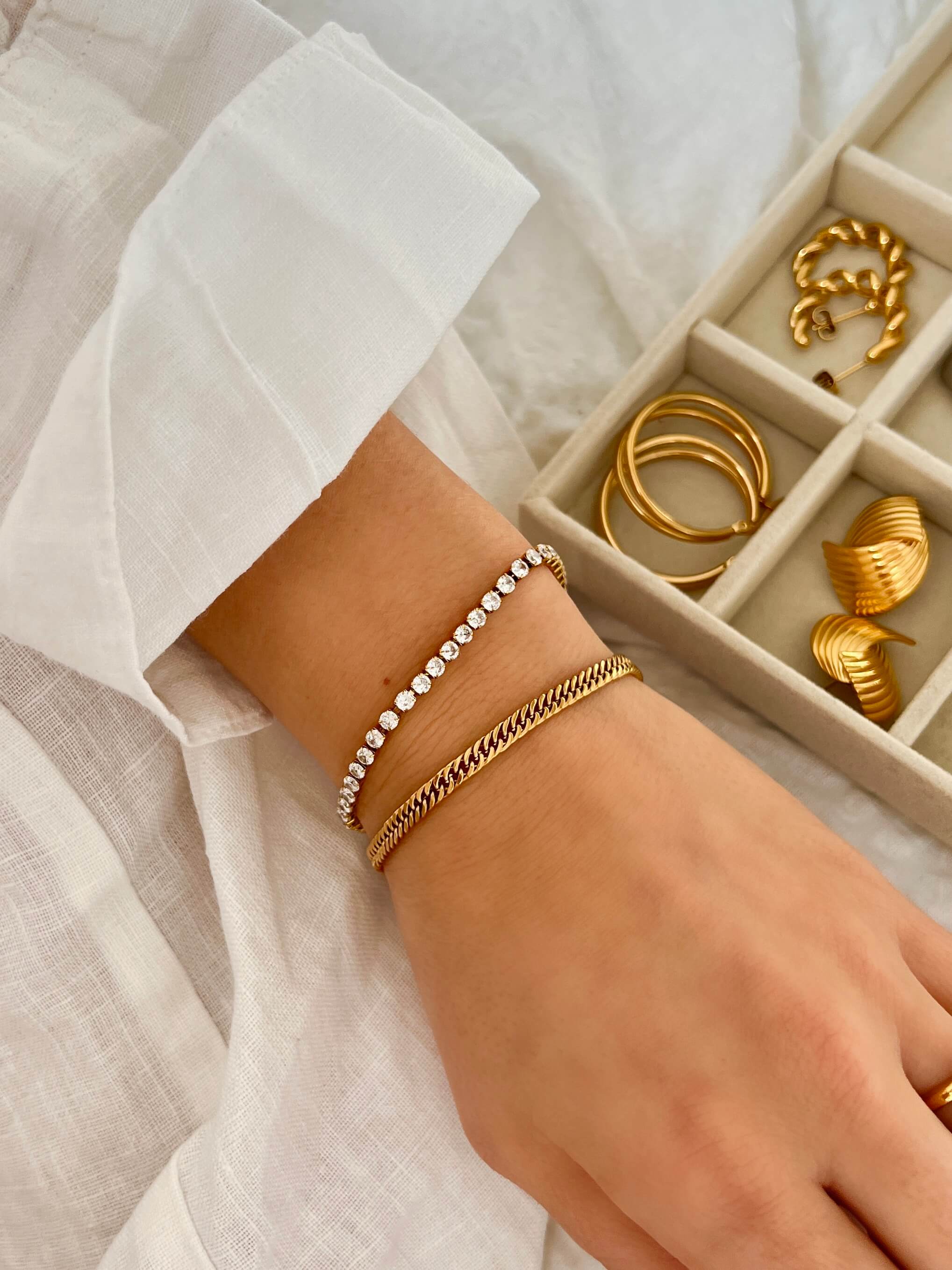 Zion Snow Bracelet – tidlöst guldarmband i elegant flat chain-design, perfekt att kombinera med andra smycken från Alora Avenue