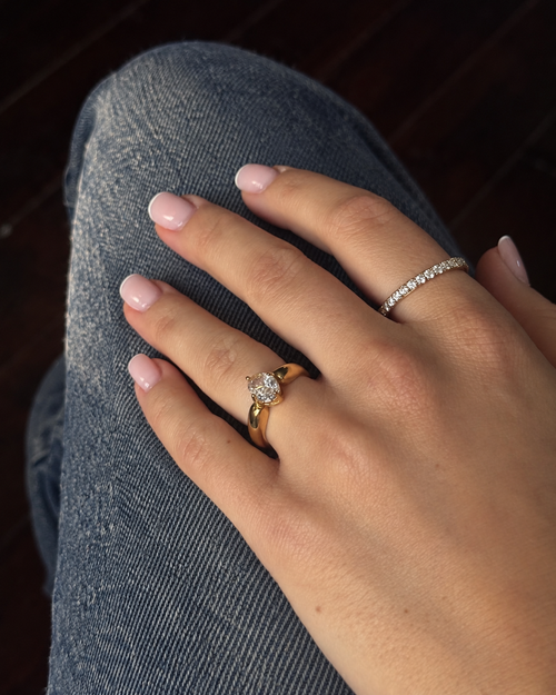 Guldringar i ringstack på modell – Adele Antique Ring med en infattad cubic zirconia-sten och Twinkle Tara Ring med en rad cubic zirconia. Vattentåliga ringar i rostfritt stål med 18K guldplätering från Alora Avenue.