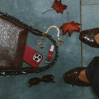 Airy Aurora Necklace i guld placerat i en elegant flatlay med höstlöv, väska och accessoarer. Stilrent och vattentåligt halsband från Alora Avenue – perfekt för vardagslyx.