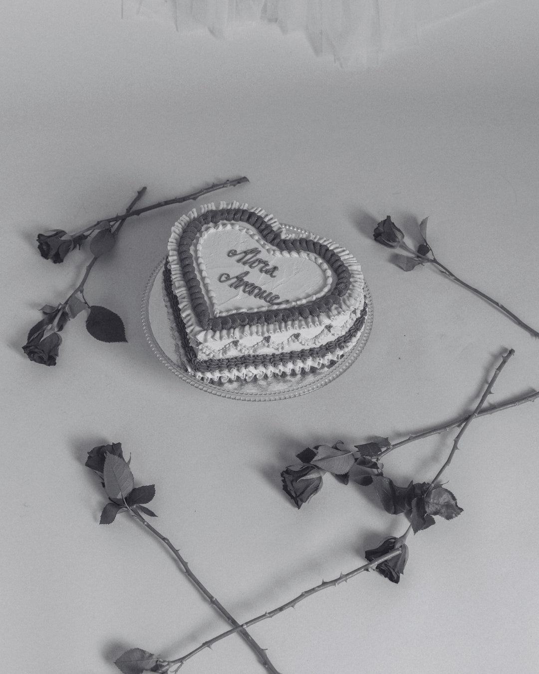 Hjärtformad jubileumstårta omgiven av röda rosor – Alora Avenue firar 2 år som svenskt smyckesmärke med vattentåliga smycken i 18K guldplätering