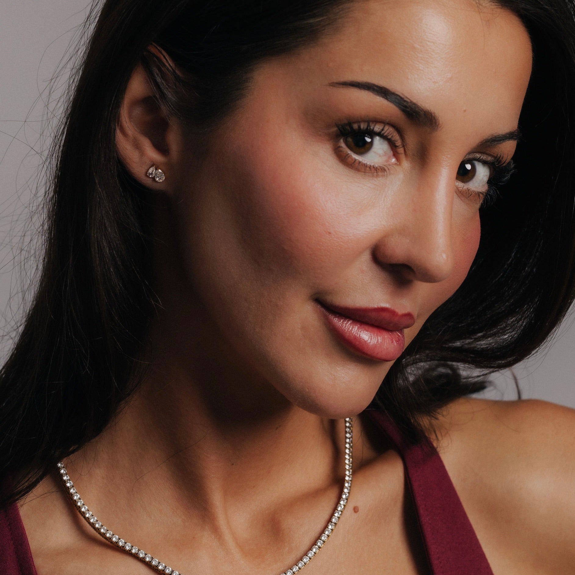 Alora Avenue Dea Drop Earrings – lyxiga 18K PVD-pläterade dubbeldroppar i rostfritt stål med glittrande stenar, bärs av modell som visar hur örhängena lyfter både vardags- och kvällslook. Perfekt för dig som vill ha eleganta, vattentåliga örhängen som håller färgen över tid.