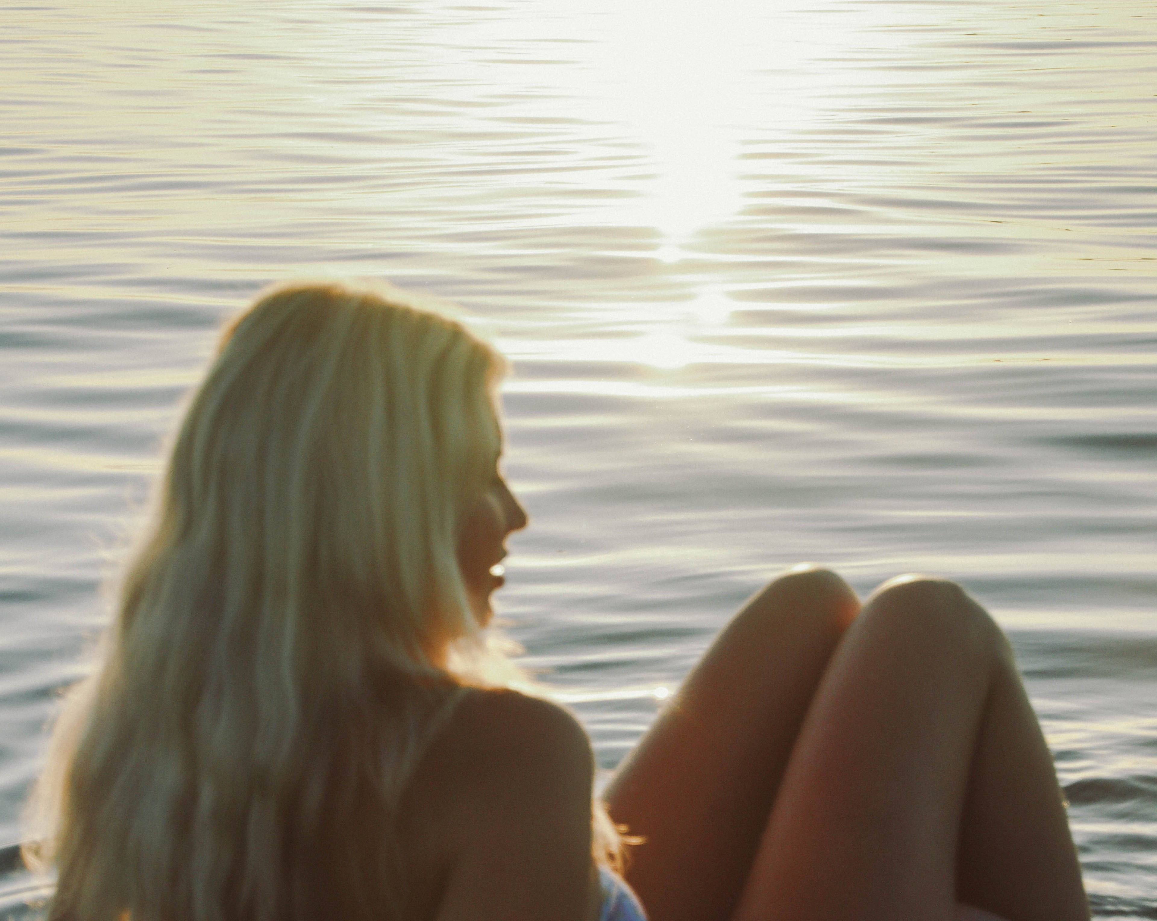 Modell vid havet bär vattentåliga smycken från Alora Avenue – tidlösa vardagssmycken designade för att bäras i sol, bad och vardag.