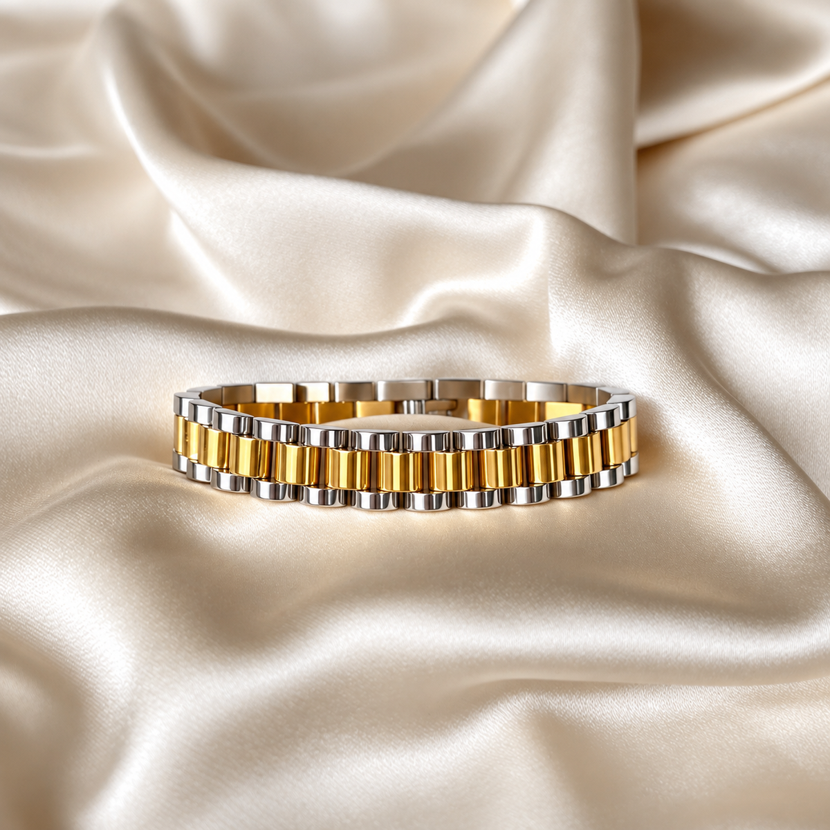 Analog Ava Wristband i guld och silver fotograferad på ljust silkestyg. Tvåfärgat, vattentåligt och allergivänligt armband i rostfritt stål från Alora Avenue.