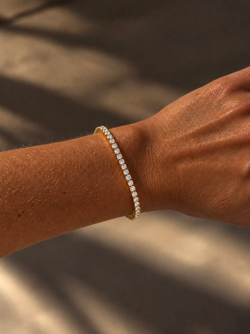 Aveline Tennis Bracelet i guld buret på modell – klassiskt tennisarmband med gnistrande cubic zirconia. Vattentåligt armband i rostfritt stål med 18K guldplätering från Alora Avenue.