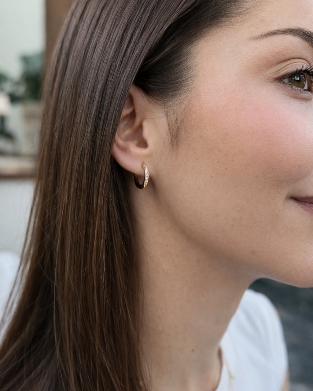 Modell bär Cassia Clip Hoop 15 mm – eleganta clip-on örhängen med sex cubic zirkonia, perfekta för dig utan hål i öronen eller för att stacka örhängen utan extra piercing.