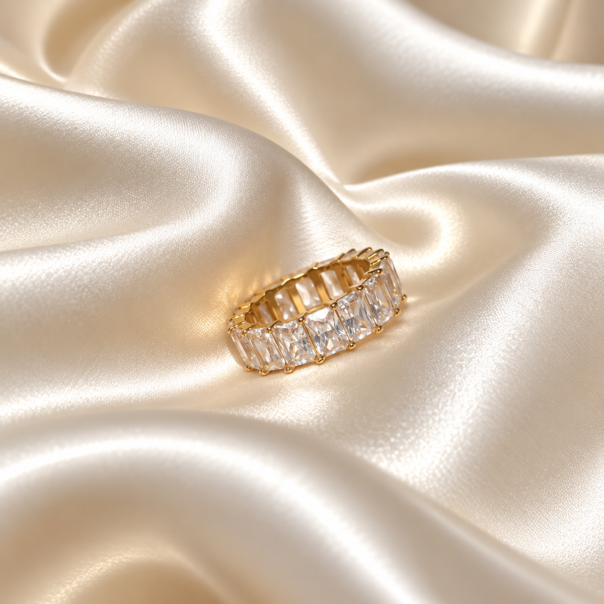 Chunky Crystal Ring i guld fotograferad på ljust silkestyg. Vattentåligt och allergivänligt smycke i rostfritt stål med 18K PVD-guldplätering från Alora Avenue.