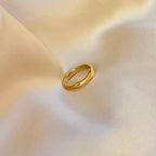 Felice Flow Ring – bred guldfärgad ring med mjuk, organisk form. Ett statement-smycke som känns både tidlöst och modernt. Tillverkad i vattentåligt och allergivänligt rostfritt stål med hållbar PVD-plätering – perfekt för både vardag och fest.