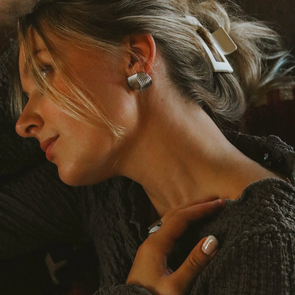 Holly Huggie Earrings i silver från Alora Avenue – eleganta, vattentåliga örhängen i rostfritt stål med mjukt vågig design som ger en modern och lyxig känsla.