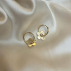 Lily Lace Loop – blommiga hoops i guldton på glansig sidenbakgrund. Vattentåliga och allergivänliga örhängen i rostfritt stål från Alora Avenue.