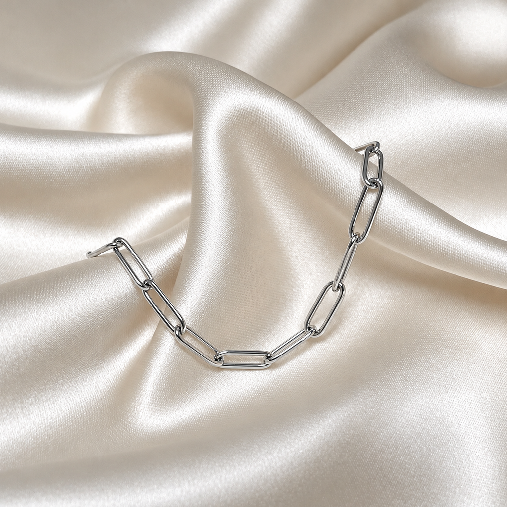 Lucid Clip Bracelet i silver fotograferad på ljust silkestyg. Vattentåligt och allergivänligt smycke i rostfritt stål från Alora Avenue.