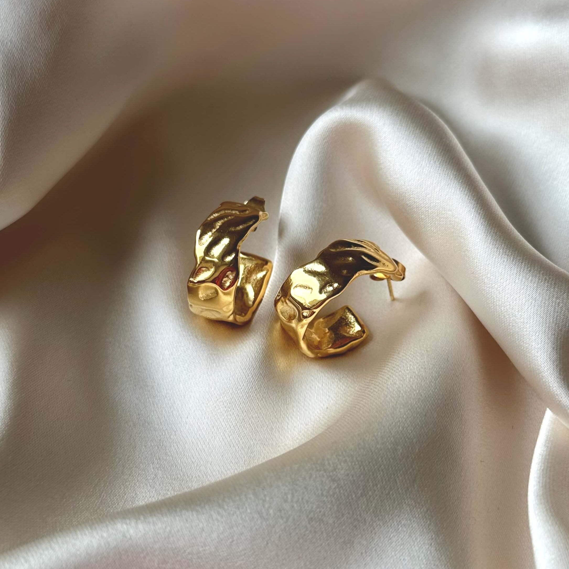 Marigold Chunky Hoops från Alora Avenue – skulpturala guldörhängen fotograferade på siden. Ett statement-smycke i vattenresistent, allergivänligt material med lyxig känsla.